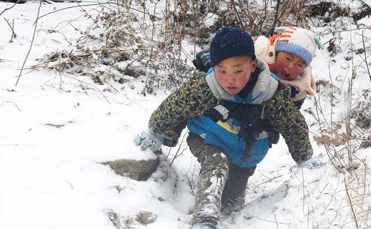 9歲男孩冒雪背弟弟搬新家 200米落差山路走了50分鐘.jpg
